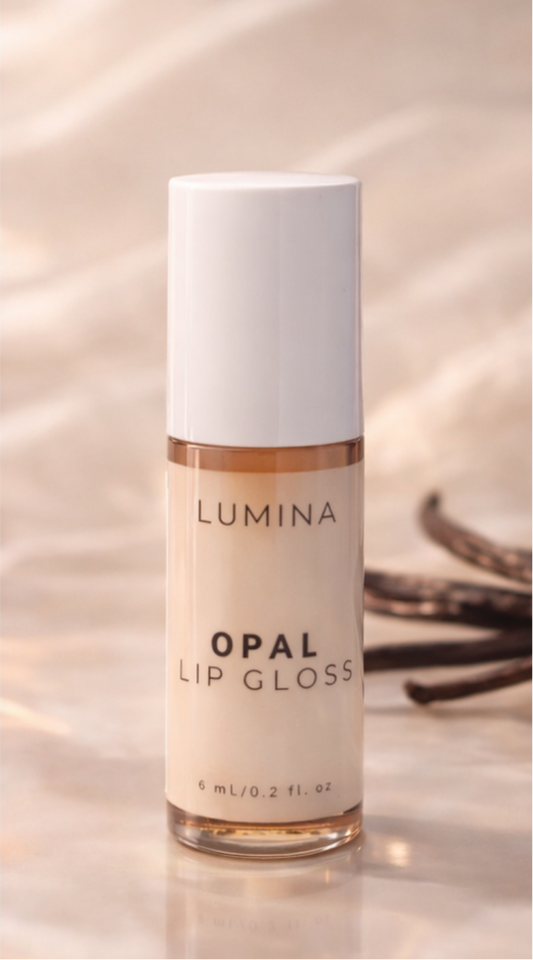 Lumina Opal lip gloss bottle on a reflective surface with a blurred background